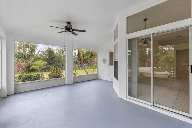 unfurnished sunroom featuring ceiling fan with notable chandelier and lofted ceiling