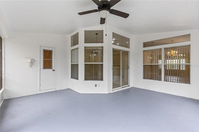 unfurnished sunroom featuring ceiling fan with notable chandelier and vaulted ceiling