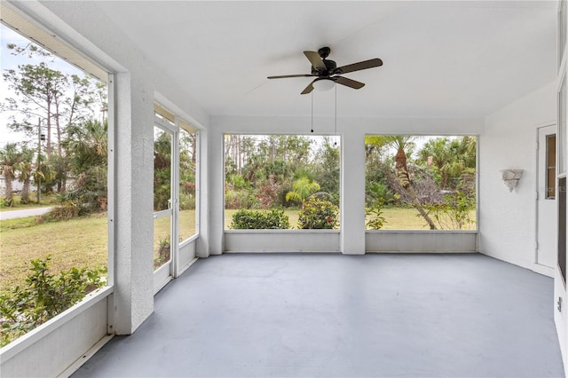 unfurnished sunroom featuring ceiling fan and a healthy amount of sunlight