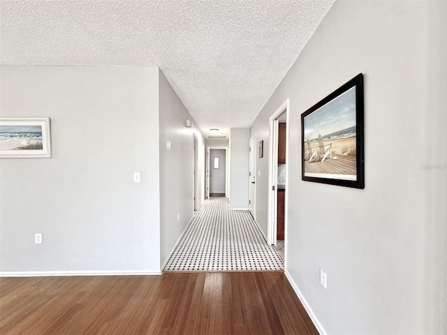 corridor featuring hardwood / wood-style floors and a textured ceiling