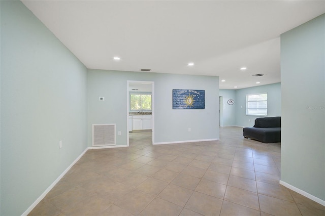 spare room with light tile patterned floors and a wealth of natural light