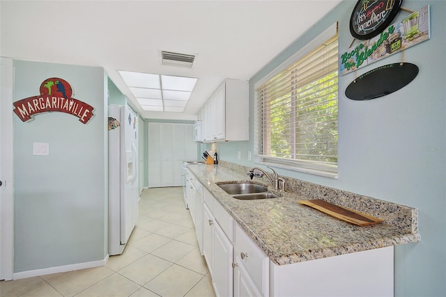 kitchen with light stone countertops, sink, light tile patterned flooring, white appliances, and white cabinets