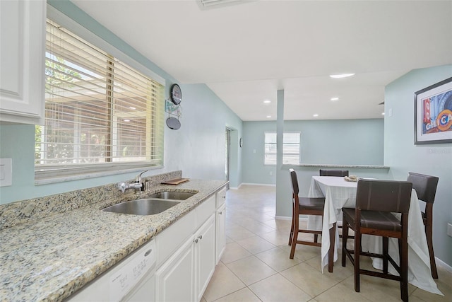 kitchen featuring white cabinetry, sink, light stone counters, white dishwasher, and light tile patterned flooring