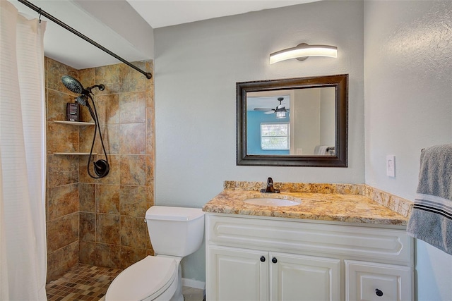 bathroom featuring ceiling fan, toilet, a tile shower, and vanity