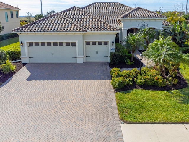 mediterranean / spanish house featuring a front yard and a garage