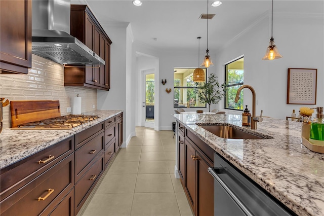 kitchen featuring stainless steel appliances, crown molding, wall chimney range hood, sink, and hanging light fixtures