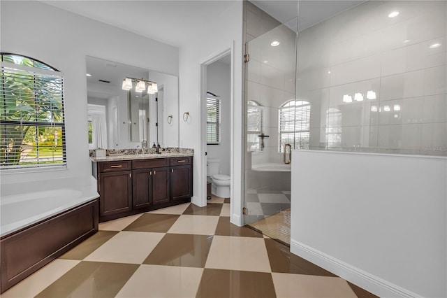 full bathroom with shower with separate bathtub, vanity, and toilet