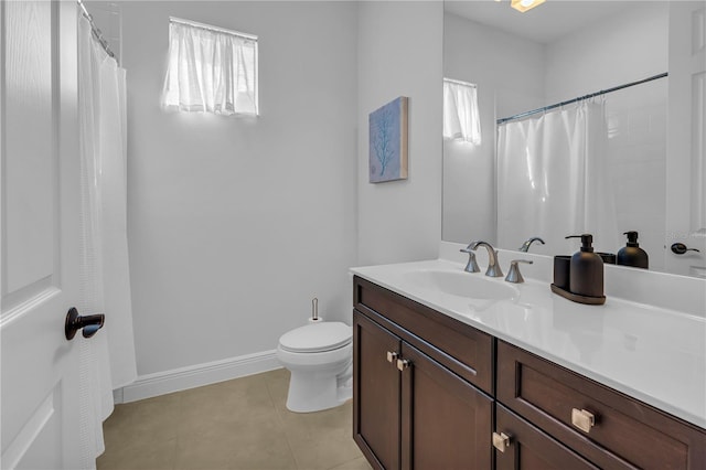 bathroom featuring tile patterned flooring, vanity, a healthy amount of sunlight, and toilet