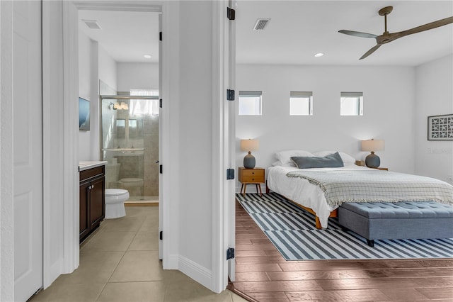 tiled bedroom featuring ceiling fan and ensuite bathroom