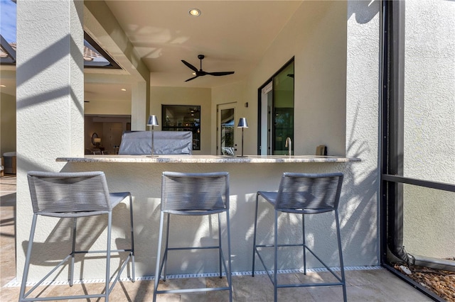 view of patio / terrace featuring exterior bar and ceiling fan