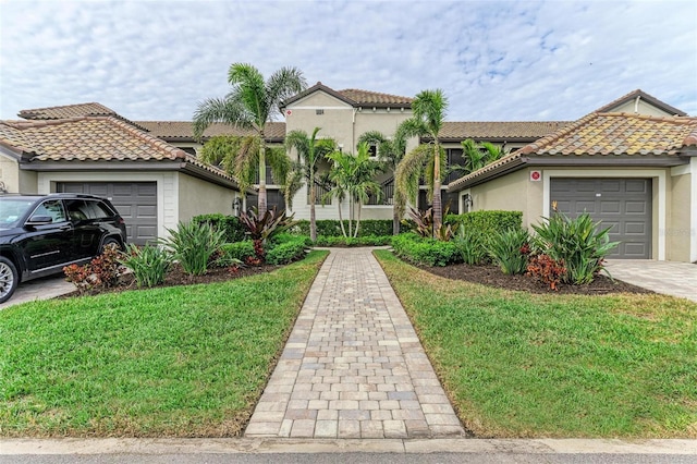 mediterranean / spanish-style home featuring a garage and a front lawn