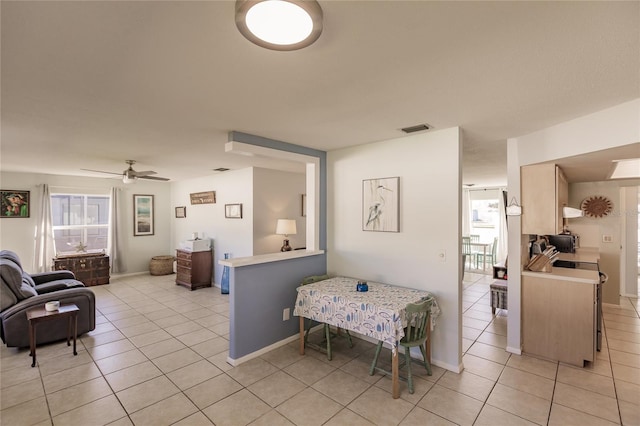 tiled dining space featuring ceiling fan