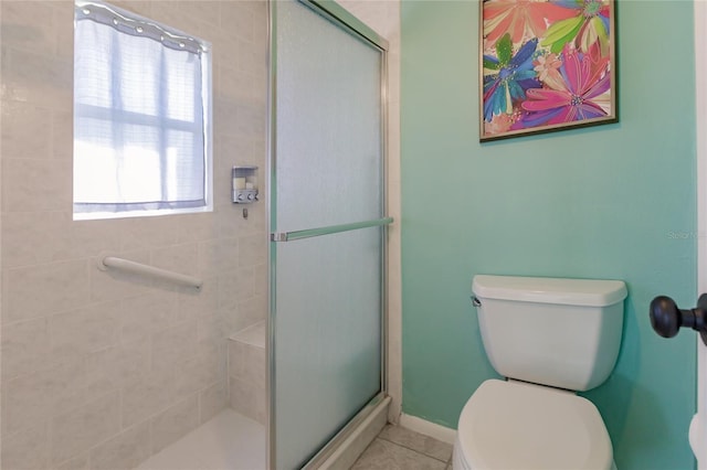 bathroom with toilet, tile patterned flooring, and a shower with door