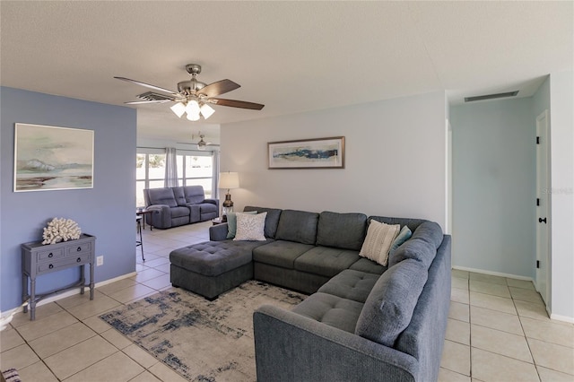 tiled living room with a textured ceiling and ceiling fan