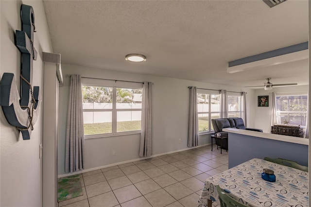 tiled living room featuring ceiling fan and a textured ceiling