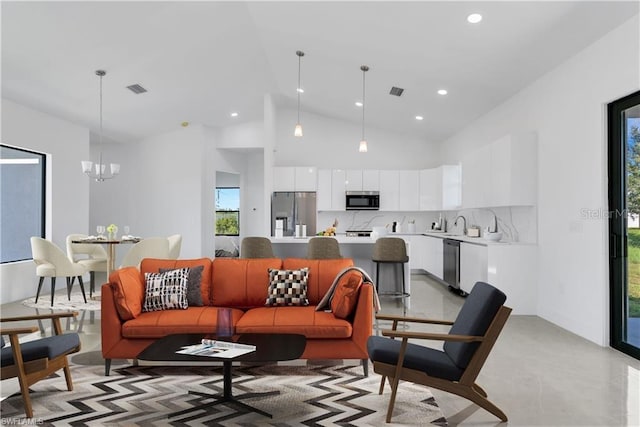 living room with high vaulted ceiling and a notable chandelier