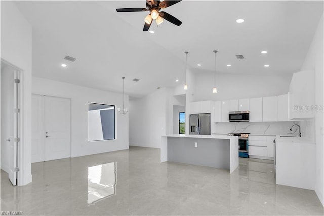 kitchen with stainless steel appliances, white cabinetry, a center island, and hanging light fixtures