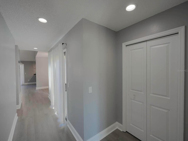 hallway featuring wood-type flooring and a textured ceiling