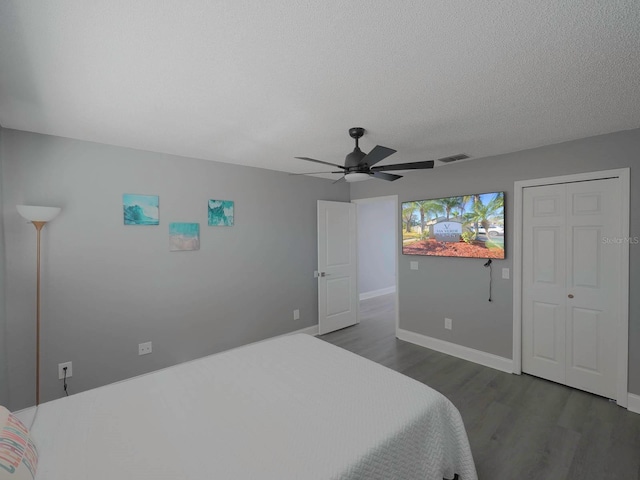 bedroom featuring ceiling fan, dark wood-type flooring, and a textured ceiling