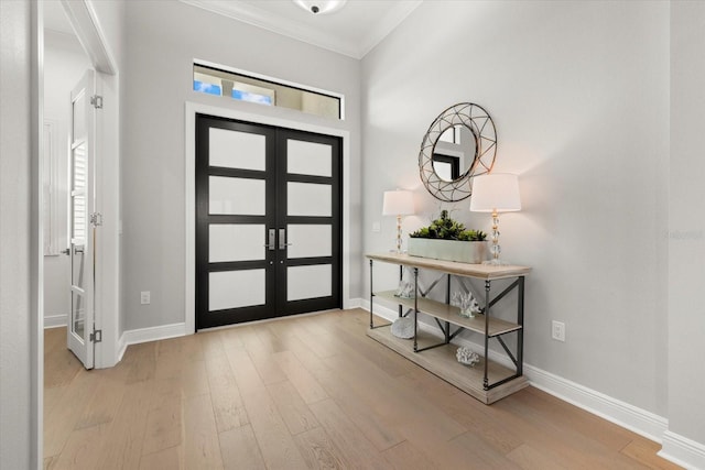 entrance foyer with crown molding, french doors, and light wood-type flooring