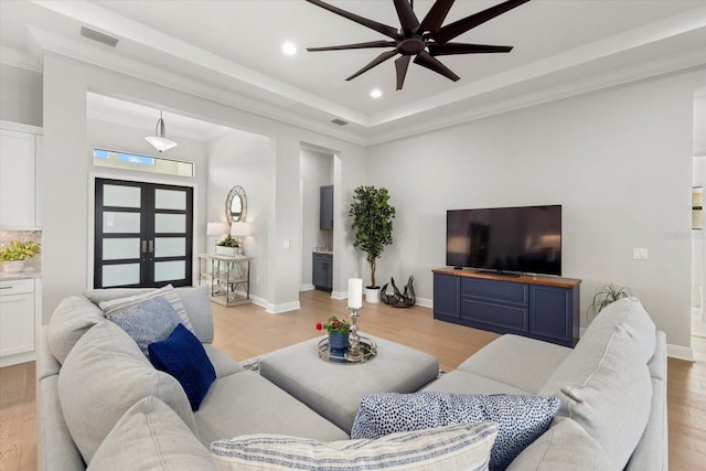 living room featuring french doors, light wood-type flooring, ceiling fan, and crown molding