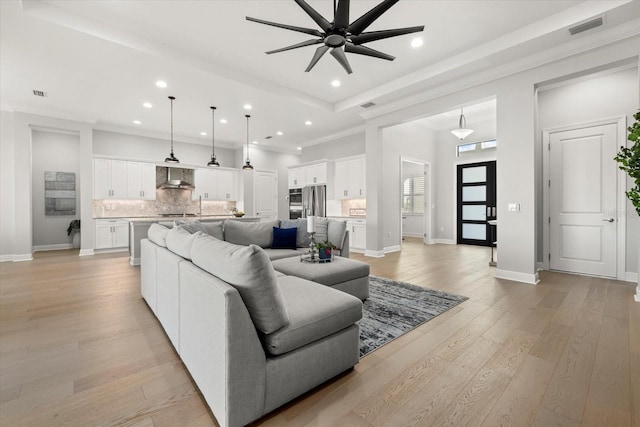 living room with ceiling fan, light hardwood / wood-style floors, and ornamental molding