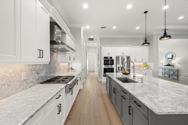 kitchen with white cabinetry, wall chimney exhaust hood, and pendant lighting