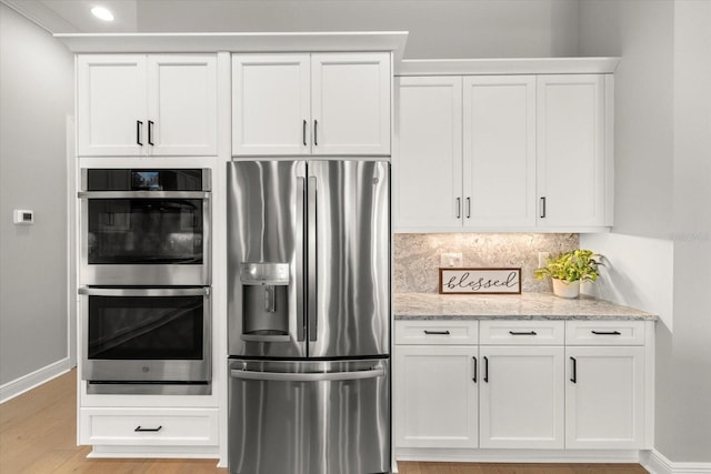 kitchen featuring light stone counters, white cabinetry, and appliances with stainless steel finishes