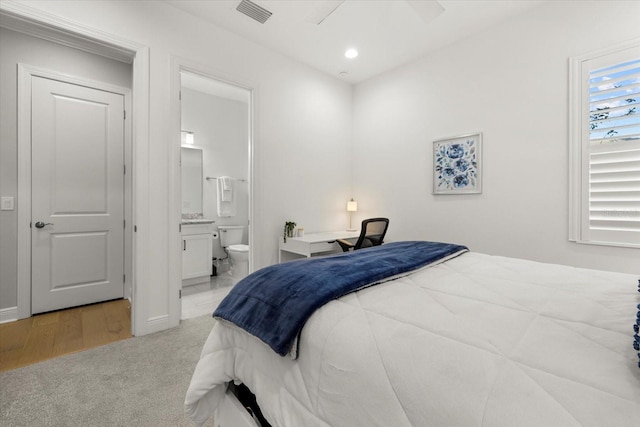 carpeted bedroom featuring ensuite bath