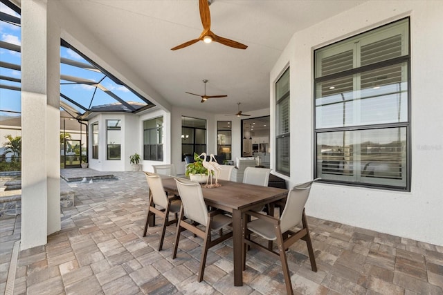 view of patio featuring glass enclosure and ceiling fan