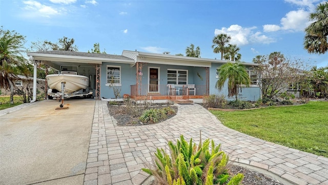 ranch-style house featuring a front lawn and a carport