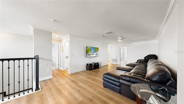 living room featuring a textured ceiling, light hardwood / wood-style flooring, ceiling fan, and ornamental molding