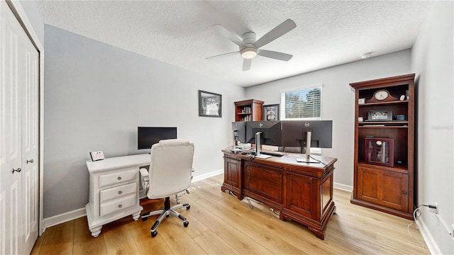 office featuring a textured ceiling, light wood-type flooring, and ceiling fan