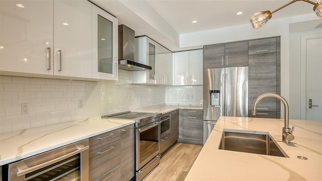 kitchen with stainless steel appliances, light stone countertops, glass insert cabinets, modern cabinets, and beverage cooler