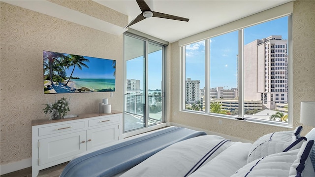 bedroom with access to exterior, ceiling fan, multiple windows, and wallpapered walls