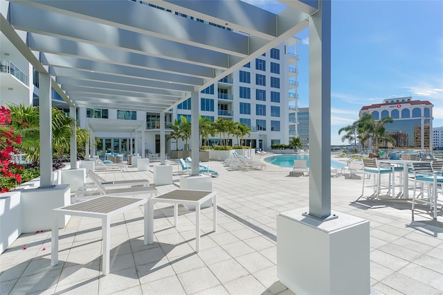 view of patio with a community pool and a city view