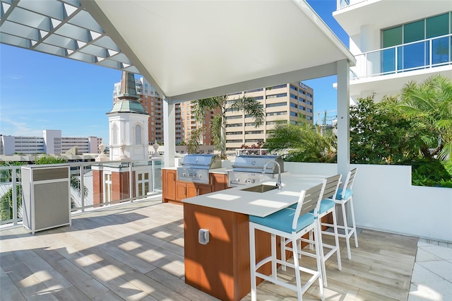 view of patio featuring a view of city, exterior kitchen, grilling area, and outdoor wet bar