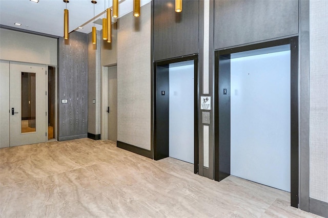 interior space with elevator and a towering ceiling