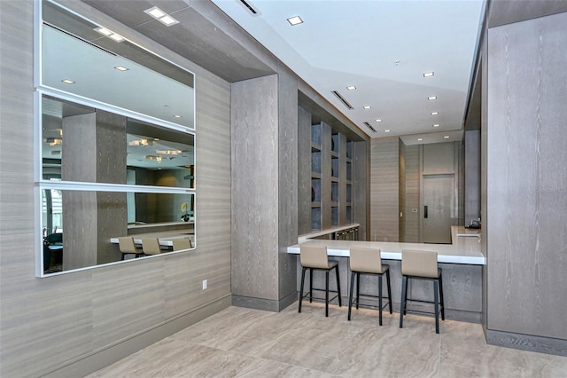 kitchen featuring a peninsula, recessed lighting, and a kitchen breakfast bar