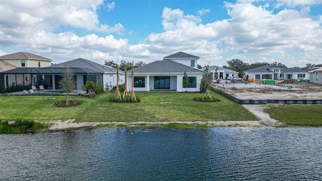 rear view of property featuring a water view, glass enclosure, and a lawn