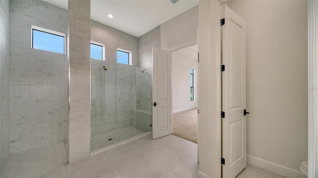 bathroom with tiled shower and toilet