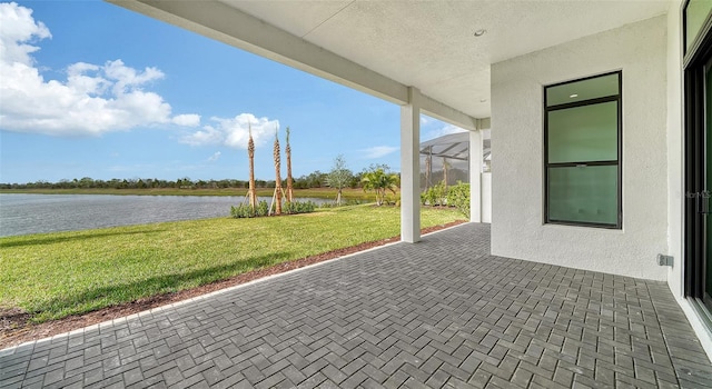 view of patio / terrace featuring a lanai and a water view