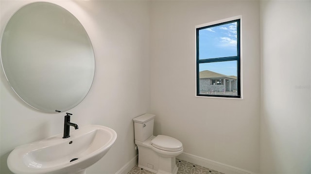 bathroom with sink, tile patterned flooring, and toilet