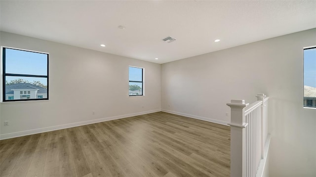 empty room with a healthy amount of sunlight and light hardwood / wood-style flooring