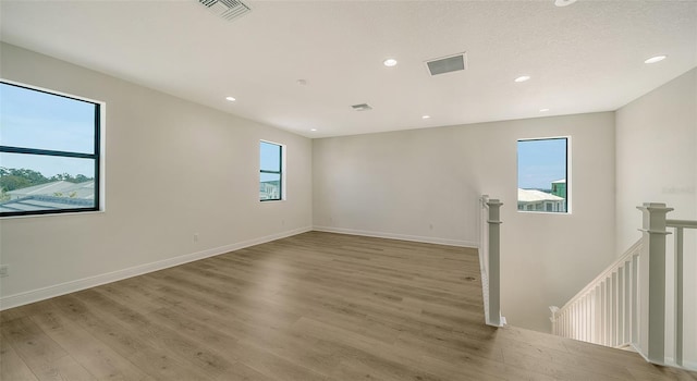 spare room featuring light wood-type flooring and a wealth of natural light