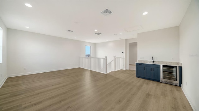 interior space with sink, light hardwood / wood-style floors, and wine cooler