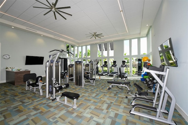 workout area featuring ceiling fan, a towering ceiling, and carpet flooring