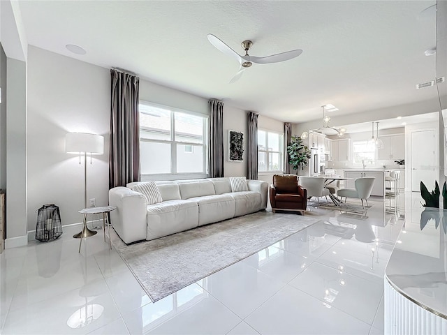 tiled living room with ceiling fan