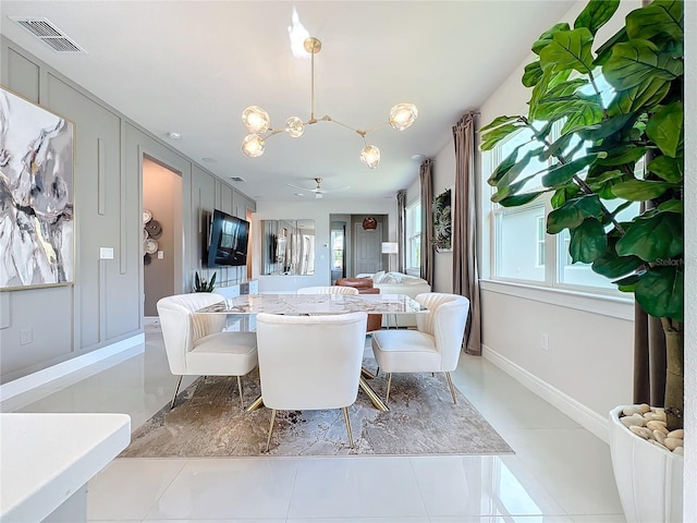 tiled dining room featuring ceiling fan with notable chandelier