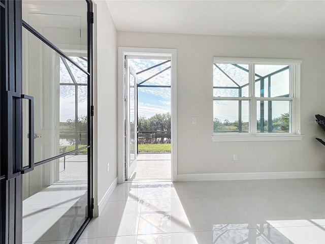 doorway to outside with light tile patterned floors and plenty of natural light